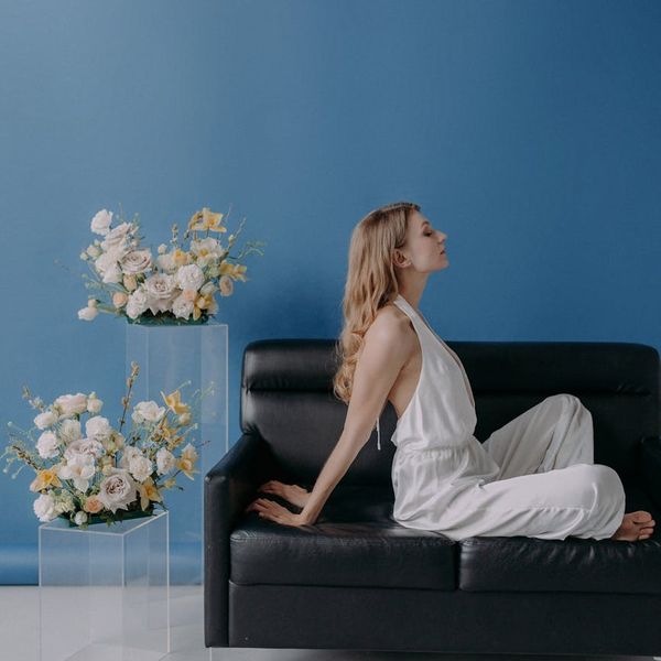 Person sitting in a meditative yoga pose against a minimalist background.